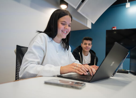 Students sit at laptop