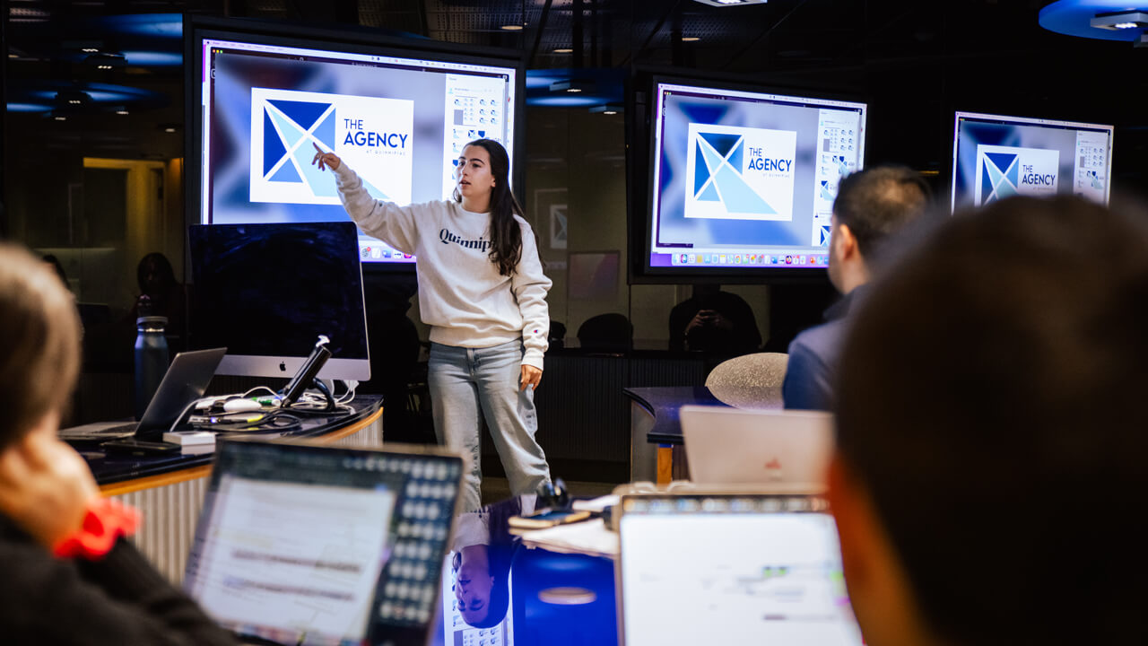 Students collaborating during a meeting for The Agency in the School of Communications.