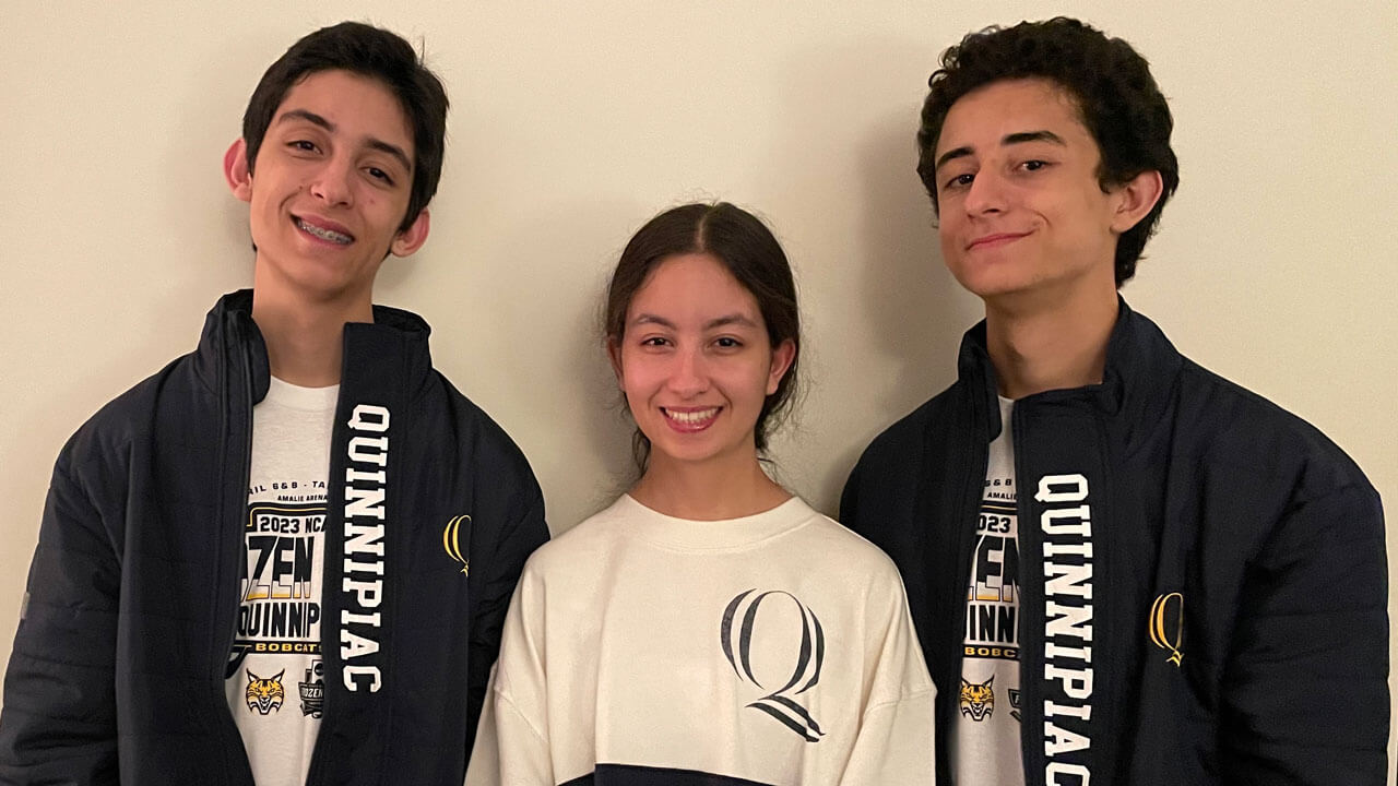 Younes, Safia and Anouar Benbrahim smile in Quinnipiac apparel.